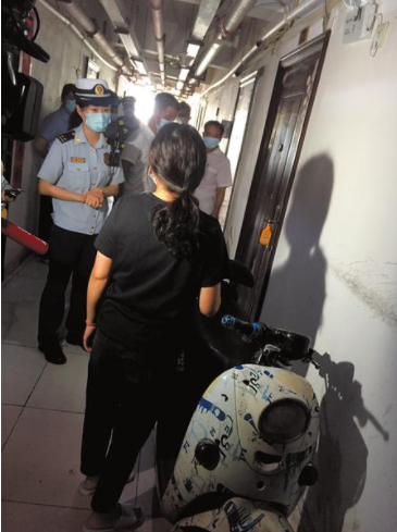 消防人员向住户耐心地讲解电动车违规充电的危害性