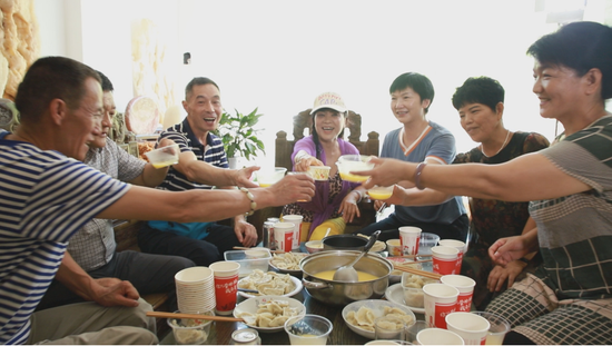  图为 “新巴马人”李荣（中间）