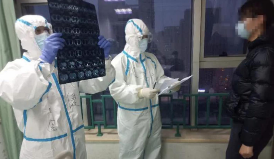 援鄂医疗队员钟健医生(左一)在为患者分析CT检