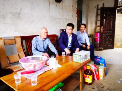 南宁市区联社党委委员、副主任邓明（右二）走访慰问退休员工