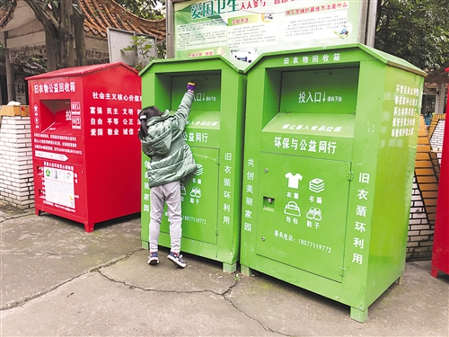 明秀小区内有身份信息标注的回收箱(红色)和没有更多身份信息的回收箱紧挨在一起 本报记者 宋延康 摄