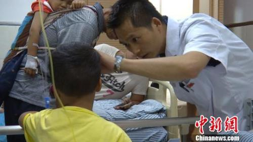 图为医生在给中毒的孩子进行检查。 孔金花 摄