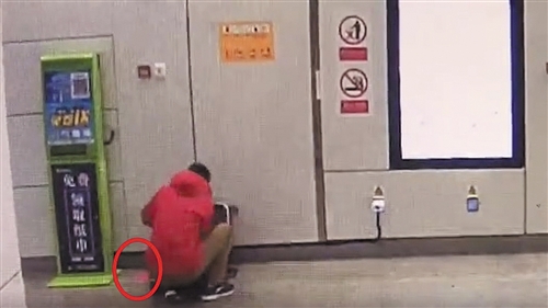红衣男子整理行李箱时,红包掉落在地未察觉(视频截图)