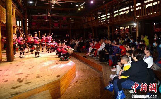 9月26日，在广西桂林市龙胜各族自治县龙脊镇黄洛瑶寨歌舞场，瑶族群众在表演长发梳妆。　潘志祥　摄
