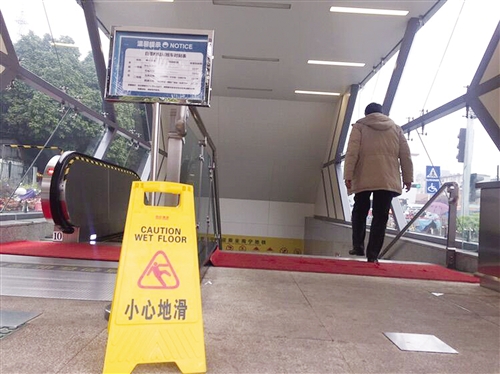阴雨天里,白苍岭站出入口摆有“小心路滑”警示牌 本报记者 周志英 摄