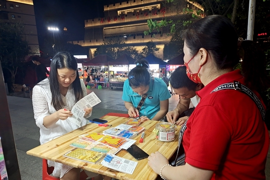 三两知己围坐在一起,刮着彩票,时不时传来欢笑声。