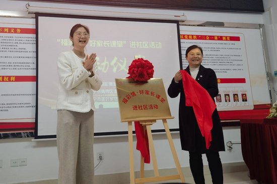广西福彩中心副主任王瑞琳（左）、建园社区党委书记何恩球（右）共同为“福彩情·好家长课堂”进社区活动揭牌