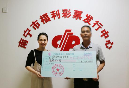 南宁市福彩中心工作人员为中奖彩民颁奖