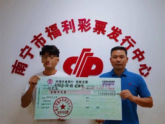 福彩中心工作人员为何先生(左)颁奖