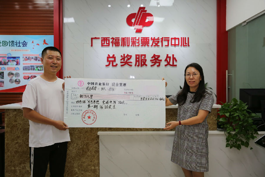 工作人员向李先生(化名)送上奖金支票
