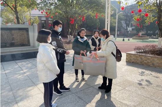 广西福彩中心工作人员向受助学送上慰问品