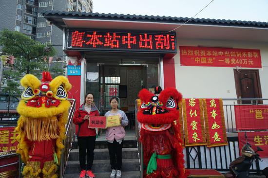 圖為南寧市福彩中心工作人員為中獎投注站業主(右)頒發獎勵金和牌匾