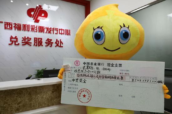 图为王先生(化姓)持中奖彩票和奖金支票合影