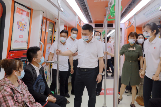 在“福彩公益号”主题地铁列车上，中心领导与乘客交流