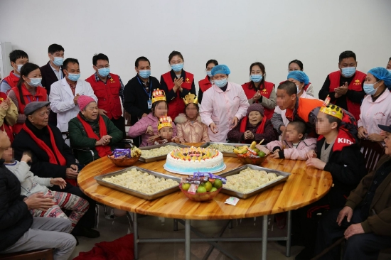 2021年11月，在来宾市社会福利院，广西福彩中心组织的走近公益金资助项目活动参与人员与院里的老人、孩子们围坐在一起，品尝着自己亲手包的饺子，并和老人、孩子们共度集体生日