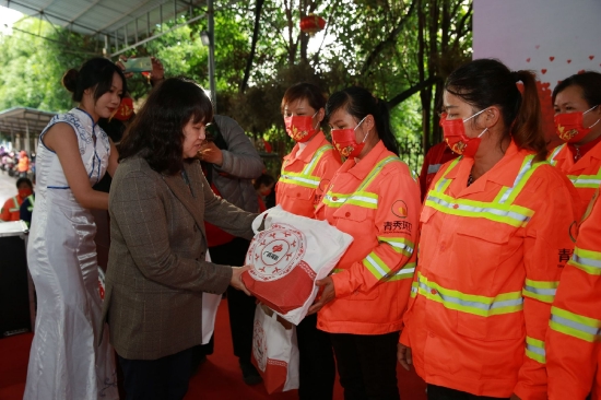 南宁市总工会权益保障部部长谢肖冰褆向环卫工人代表发放健康礼包