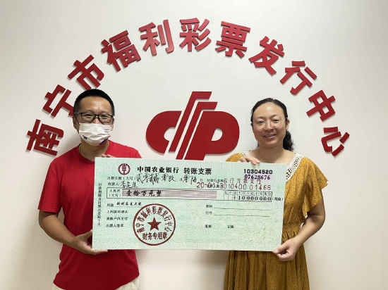 南宁市福彩中心工作人员为李先生(左)颁奖