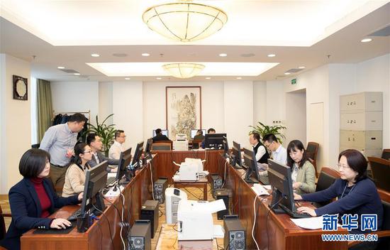 3月12日,十三届全国人大二次会议秘书处工作人员在认真工作(金立旺 摄)