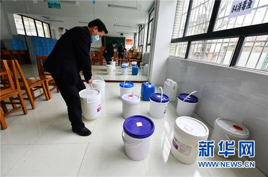 3月15日,贵阳市第二十三中学的老师在搬运为开学准备的消毒液。新华社记者 杨文斌 摄