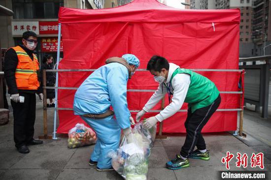 图为配送人员把商品送至小区指定收取区域。 瞿宏伦 摄