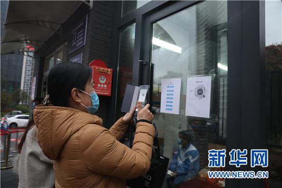 3月16日,贵阳市第二实验中学的教职员工在进入学校前扫“健康码”。新华网 卢志佳 摄
