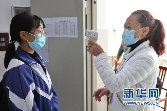 3月16日,贵阳市第六中学高三住校学生在进入宿舍前接受体温检测。新华社记者 欧东衢 摄