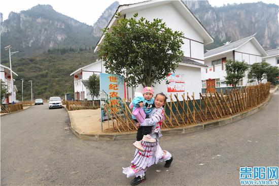 化屋村易地扶贫搬迁点上,一名当地少数民族村民喜笑颜开。