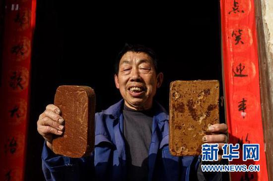 72岁的宋光平在展示自己亲手做的红糖。当年救助过红军的红糖,现在成了村民致富发展的支柱产业。(新华社记者欧东衢2021年4月21日摄)