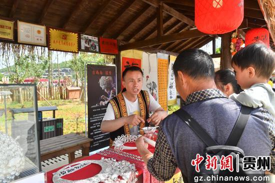 党员诚信经营户为游客介绍产品。