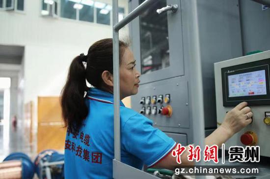 资料图:在中安电器科技产业园的生产车间内,工人正在调试绕包机操作数据,保证机械正常运转。