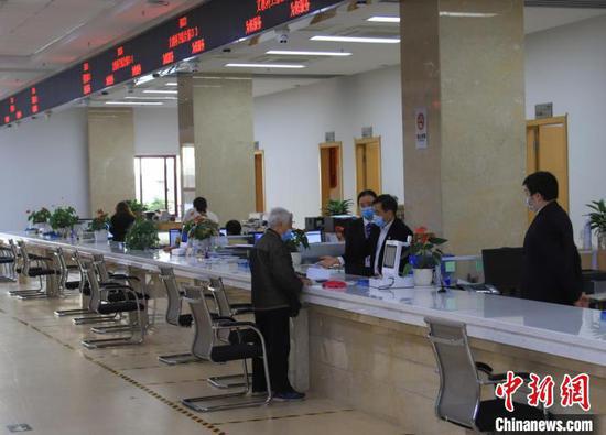 图为贵州省政务服务大厅窗口工作人员为老年人办事。贵州省政务服务中心供图