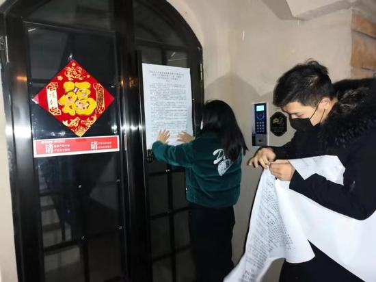 工作人员冒着严寒深入居民楼栋张贴疫情防控公告