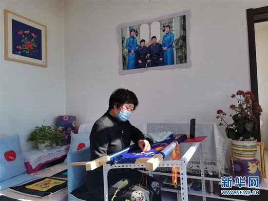 内蒙古兴安盟科尔沁右翼中旗绣娘王金莲在家通过手机视频教授蒙古族刺绣(2020年2月27日摄)。新华社发(白俊华摄)