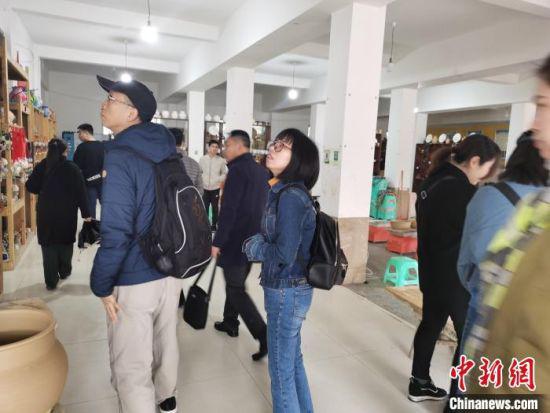 11月22日,两岸媒体文化交流参访团来到花茂村。图为参访团成员参观陶器工艺品。 张舵 摄