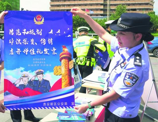 贵安民警在展示防范经济犯罪海报。