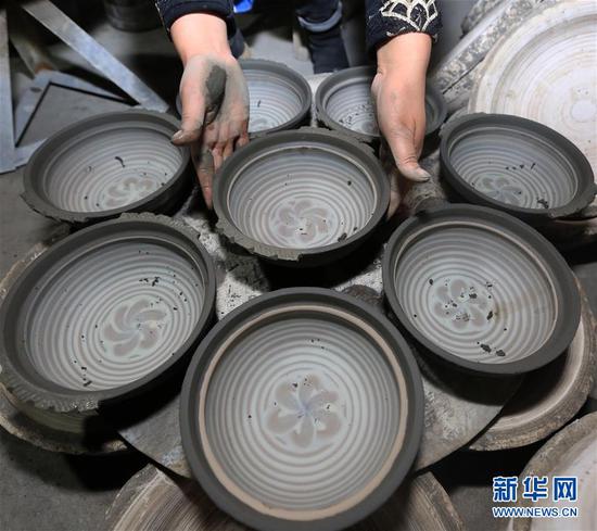 10月9日,贵州省毕节市织金县一砂陶制品厂的工人在整理砂陶半成品。新华社发(王纯亮 摄)