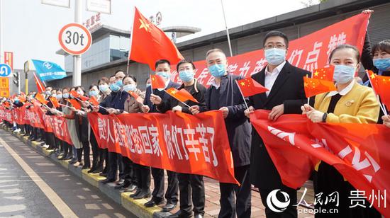 贵州省人民医院职工前往机场欢迎援鄂医疗队队员回家。武敏 摄