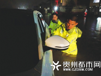民警蹚水排查积水中车辆是否有被困人员