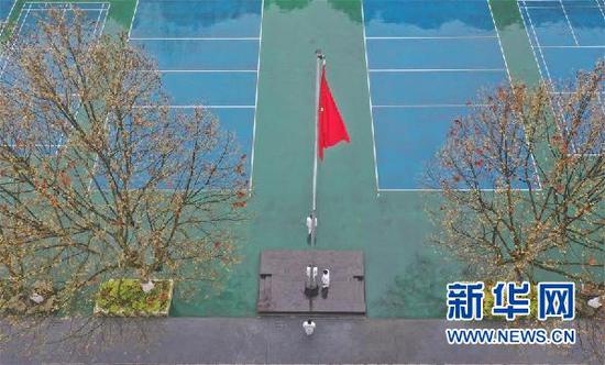 3月16日,贵阳市第六中学国旗班学生在操场上升旗,其余同学则在教室内参加升旗仪式。新华社记者 欧东衢 摄