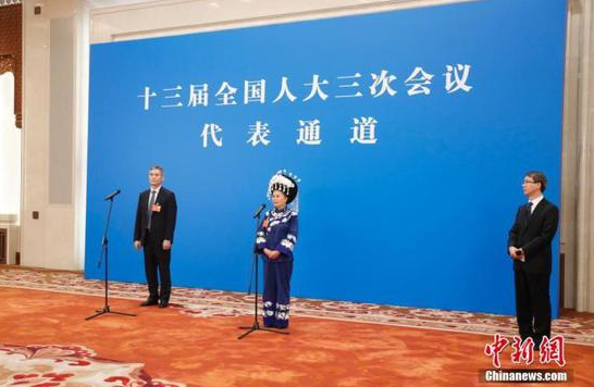 5月22日,第十三届全国人民代表大会第三次会议在北京人民大会堂举行首场“代表通道”采访活动。图为全国人大代表罗杰(左)、石丽平(中)通过网络视频方式接受采访。 中新社记者 杜洋 摄