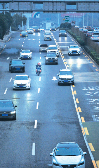 一辆电瓶车行驶在中环道路中间车道上