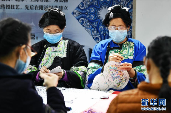 4月2日,在贵州省榕江县卧龙移民小区一刺绣扶贫车间,几名妇女在学习按订单设计的图案刺绣。