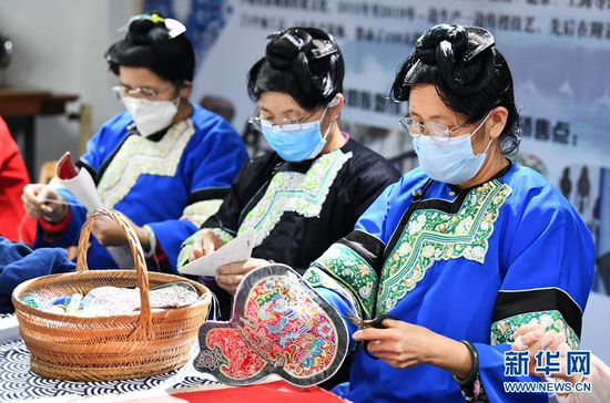 4月2日,在贵州省榕江县卧龙移民小区一刺绣扶贫车间,几名妇女在学习按订单设计的图案刺绣。