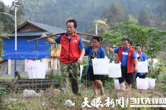 九秋村驻村干部帮助村民们挑水