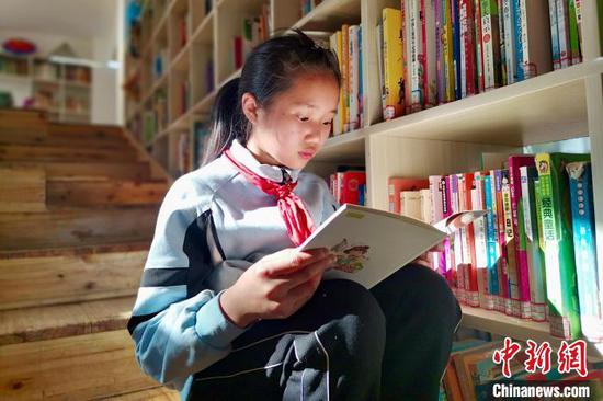 图为当地儿童在三宝儿童图书馆开馆当日看书学习。 张冬冬 摄