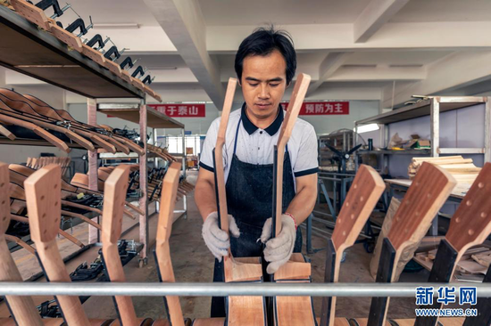 6月24日,工人在吉他生产车间内忙碌。