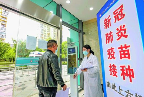 在贵州医科大学大学城医院,前来接种的市民在接受体温监测。