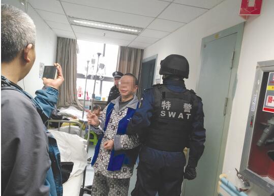 甘某被押解到医院指认作案现场。
