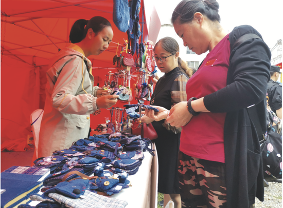 市民在非遗集市上购买手工作品