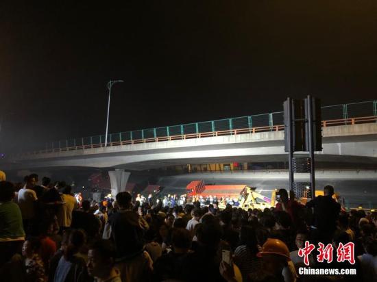 10月10日晚,江苏无锡,312国道上海方向锡港路上跨桥路段出现桥面垮塌,现场有多辆轿车被压,具体伤亡情况不详。救援车辆已抵达现场。周边道路已被封闭,当地交警正在进行分流疏导。目前救援工作正在进行中,具体伤亡情况也在统计当中。孙权 摄